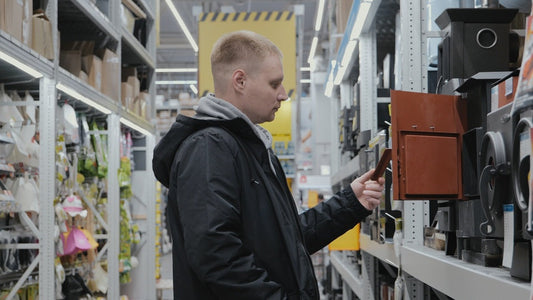 Person shopping for discount HVAC equipment in a warehouse store aisle