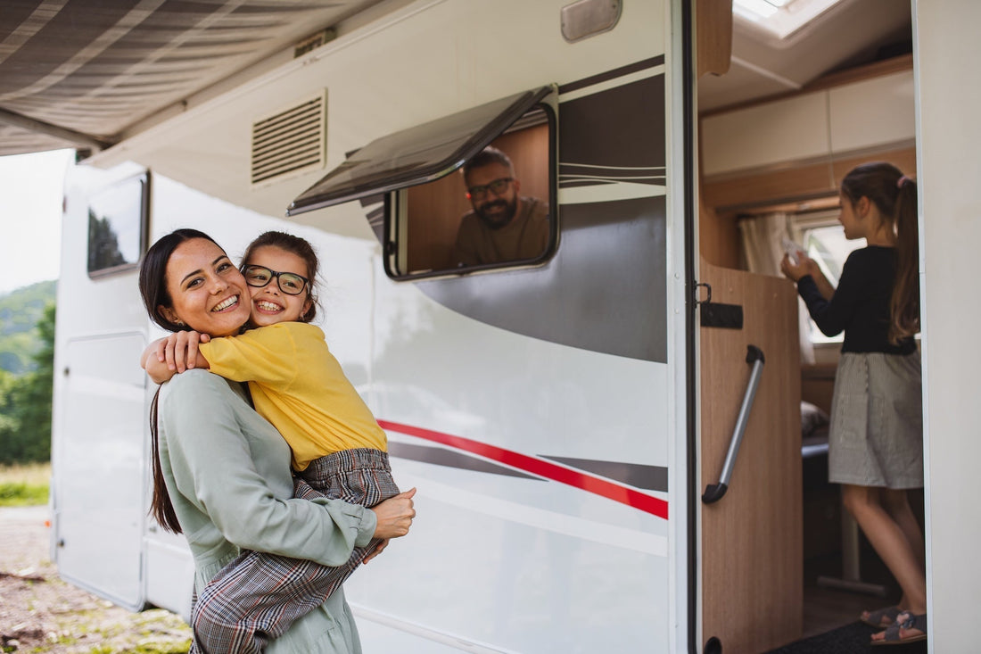 Family enjoying time outside their RV camper on a road trip